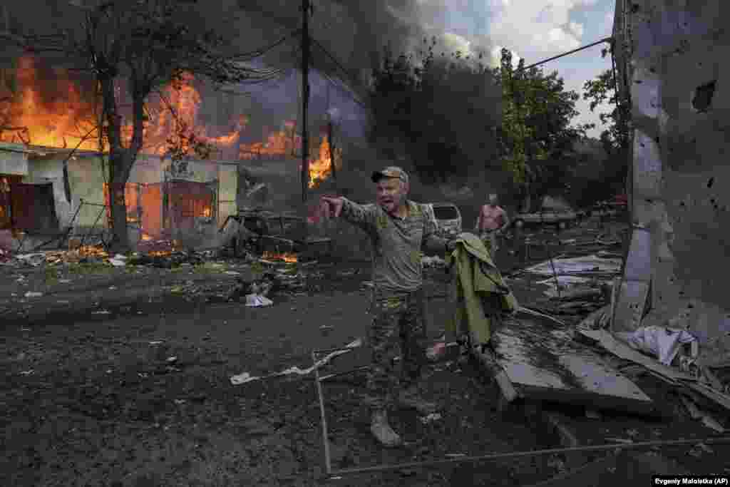 Украинский военнослужащий кричит парамедикам перед телами погибших в результате ракетного обстрела продовольственного рынка в центре Константиновки. Украина, 6 сентября 2023 года.&nbsp;(AP Photo/Evgeniy Maloletka)