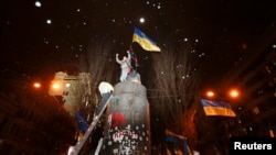 Участники "евромайдана" взобрались на пьедестал снесенного памятника Ленину в Киеве