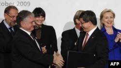 Switzerland -- Turkish Foreign Minister Ahmet Davutoglu (2ndR) and his Armenian counterpart Eduard Nalbandiana (2nd L) shake hands as they hold signed documents after a signing ceremony, Zurich, 10Oct2009