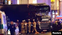 GERMANY--Police and emergency workers stand next to a crashed truck at the site of an accident at a Christmas market on Breitscheidplatz square near the fashionable Kurfuerstendamm avenue in the west of Berlin/December 19, 2016. REUTERS